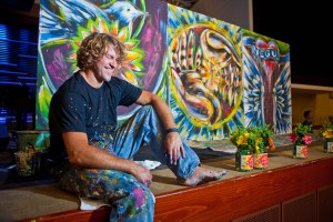 Artist Tom Clark in front of his live painting, "Joy".